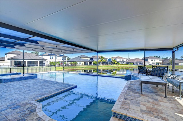 view of pool with a lanai, a patio area, a water view, and an in ground hot tub