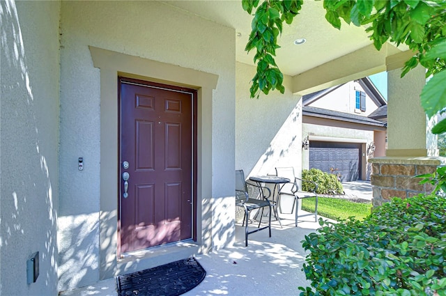 doorway to property featuring a porch and a garage