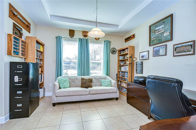 office featuring a tray ceiling, light tile patterned flooring, and a textured ceiling