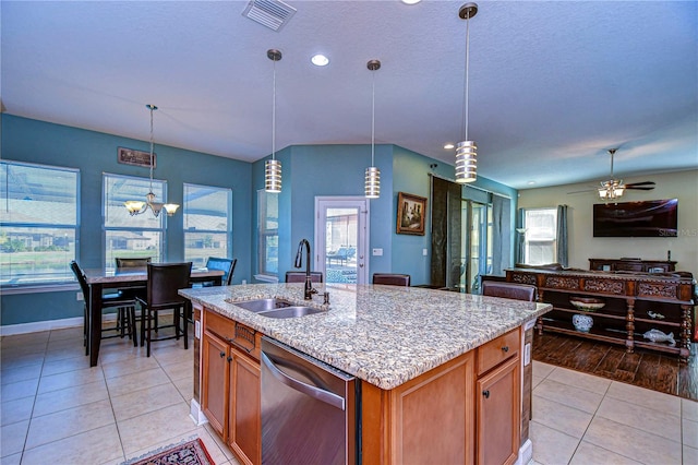 kitchen featuring dishwasher, sink, hanging light fixtures, light hardwood / wood-style flooring, and an island with sink