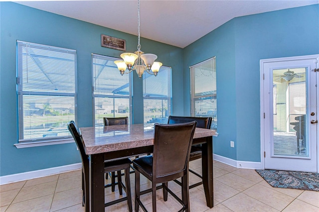 dining area with ceiling fan with notable chandelier and light tile patterned floors