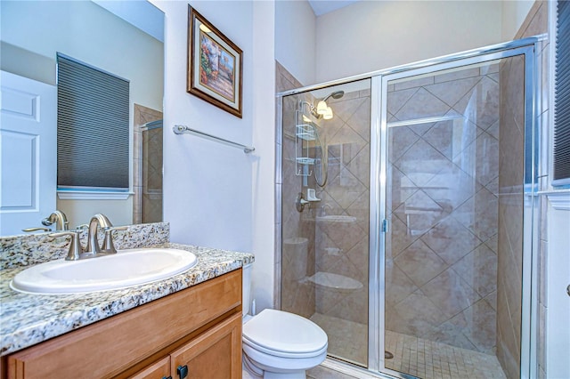 bathroom with vanity, toilet, and an enclosed shower