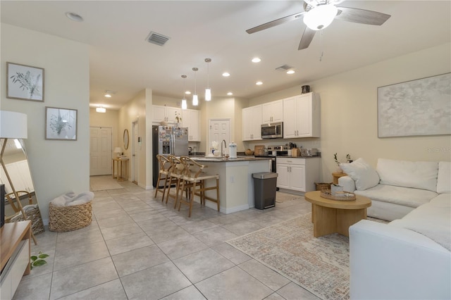 living room with ceiling fan, light tile patterned flooring, and sink