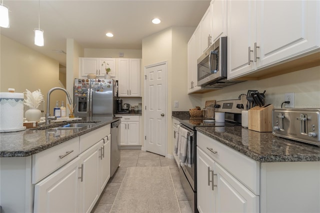 kitchen with white cabinetry, sink, hanging light fixtures, a center island with sink, and appliances with stainless steel finishes