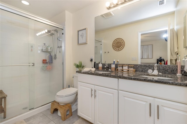 bathroom with tile patterned floors, vanity, toilet, and walk in shower