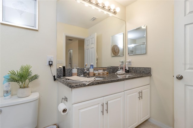 bathroom featuring vanity and toilet