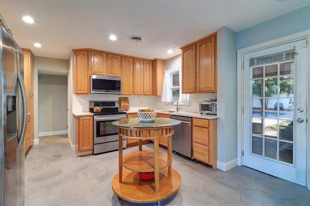 kitchen featuring tasteful backsplash, sink, light tile patterned floors, and stainless steel appliances