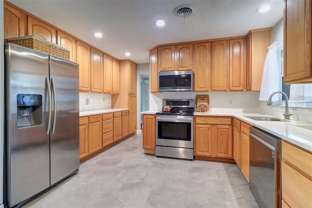 kitchen with tasteful backsplash, sink, light tile patterned flooring, and appliances with stainless steel finishes