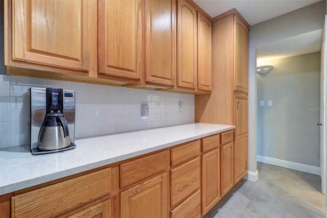 kitchen with light stone countertops, light tile patterned floors, and tasteful backsplash