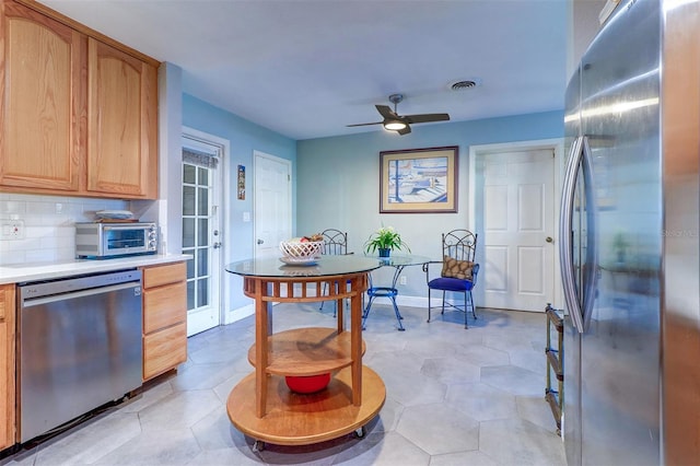 kitchen featuring decorative backsplash, ceiling fan, light tile patterned floors, and stainless steel appliances