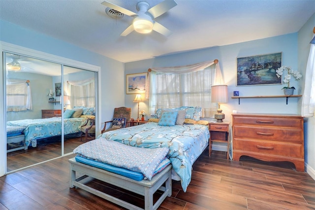 bedroom featuring a closet, dark wood-type flooring, and ceiling fan