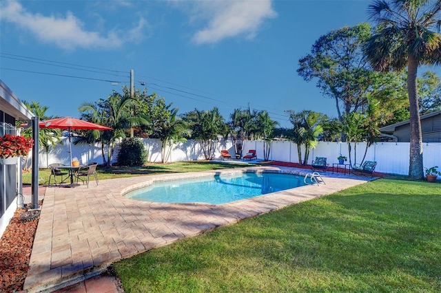 view of pool with a lawn and a patio