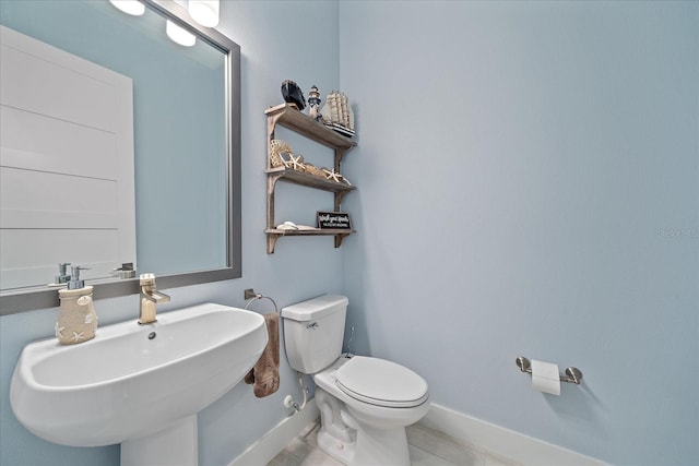 bathroom with tile patterned flooring, toilet, and sink