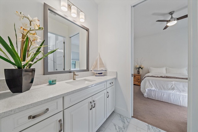 ensuite bathroom with marble finish floor, a ceiling fan, vanity, ensuite bath, and baseboards