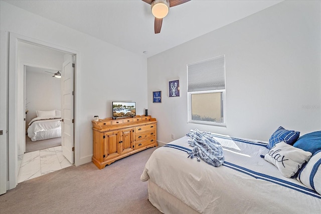 bedroom featuring connected bathroom, marble finish floor, carpet flooring, and ceiling fan