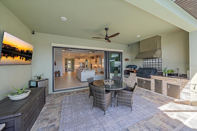 view of patio with ceiling fan, grilling area, outdoor dining area, exterior kitchen, and a sink