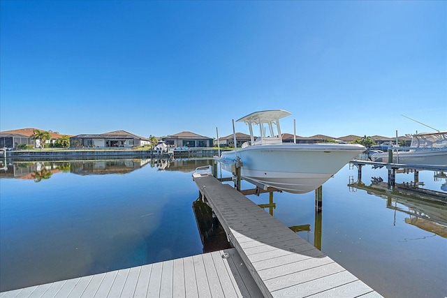 dock area featuring a water view, boat lift, and a residential view