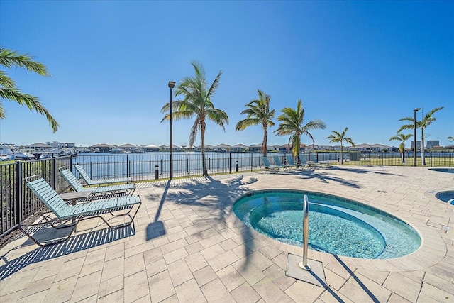 view of swimming pool featuring a patio, fence, a residential view, and a hot tub