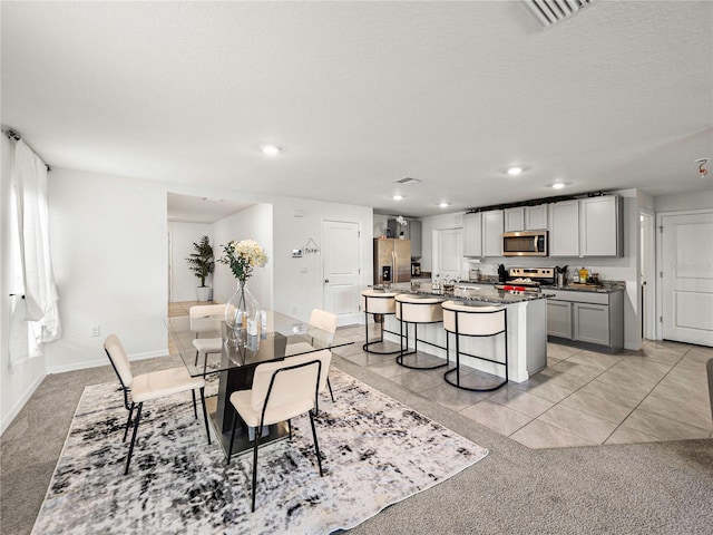 dining space with light carpet, a textured ceiling, and sink