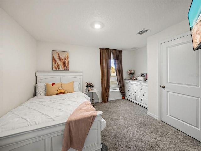 bedroom featuring light carpet and a textured ceiling