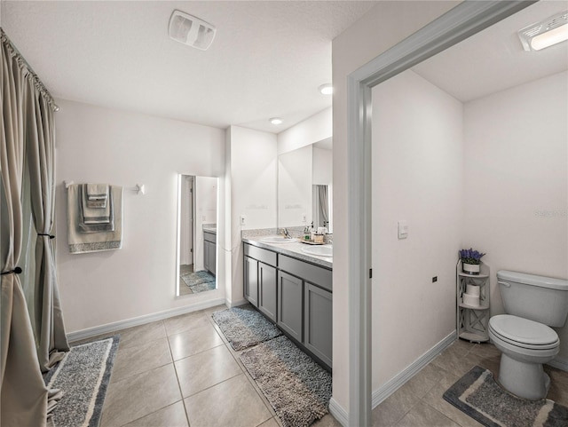 bathroom featuring tile patterned flooring, vanity, and toilet