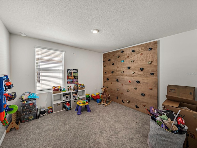 rec room featuring carpet and a textured ceiling