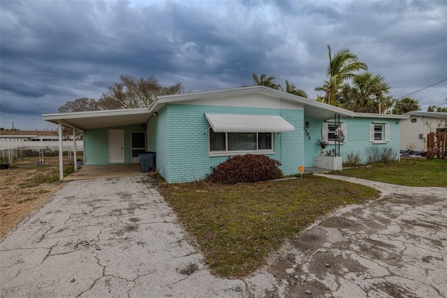 view of front of home with a carport and a front lawn