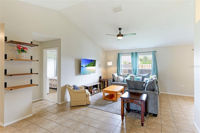 living room featuring ceiling fan, lofted ceiling, and light tile patterned floors