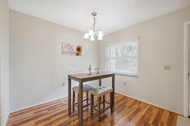 dining room featuring a chandelier, a textured ceiling, and light hardwood / wood-style flooring