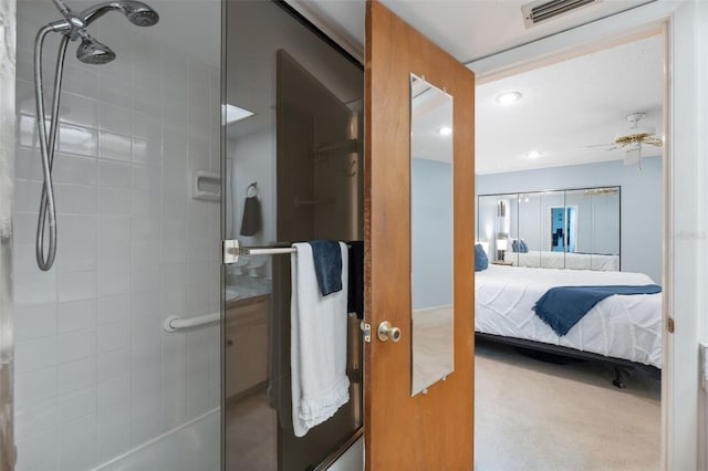 bathroom with ceiling fan and tiled shower