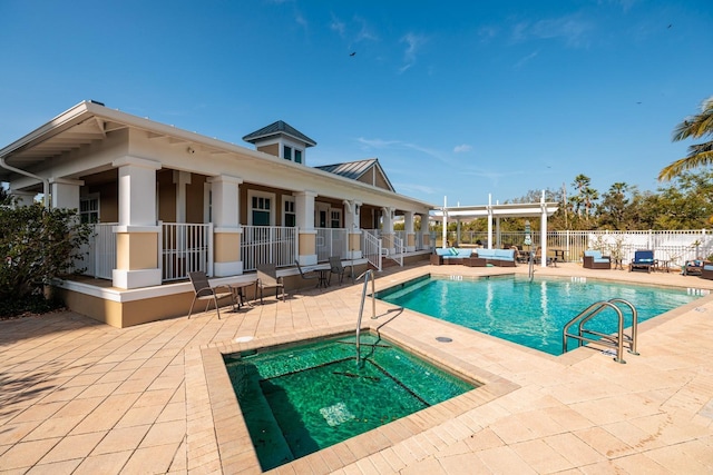 view of swimming pool featuring a hot tub and a patio area