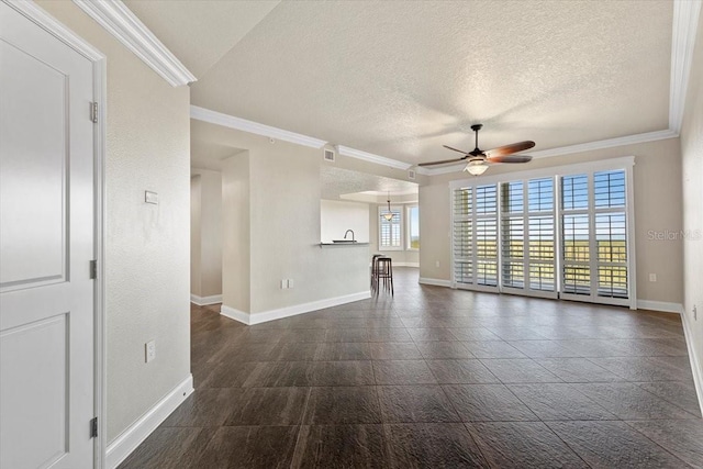 unfurnished living room with ceiling fan, a textured ceiling, and ornamental molding