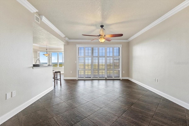 empty room featuring ceiling fan, a healthy amount of sunlight, a textured ceiling, and ornamental molding