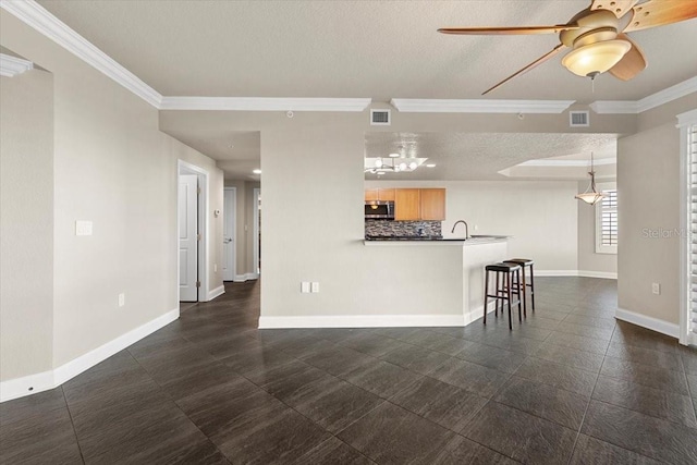 unfurnished living room with ceiling fan, a textured ceiling, and ornamental molding