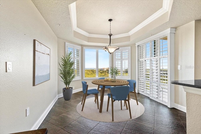 dining space featuring a raised ceiling, ornamental molding, and a textured ceiling