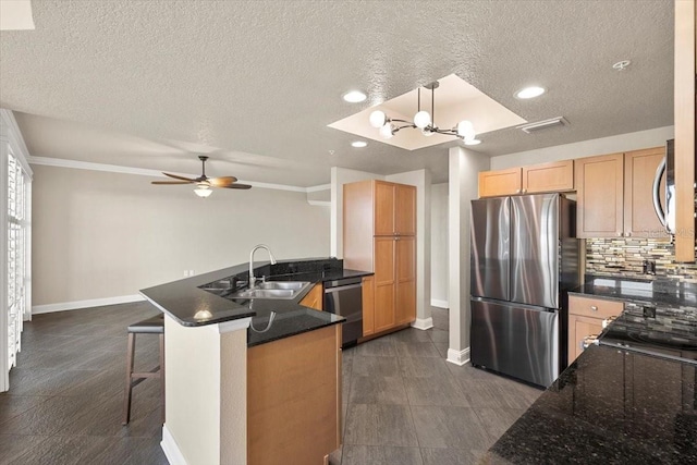 kitchen with sink, hanging light fixtures, appliances with stainless steel finishes, tasteful backsplash, and kitchen peninsula