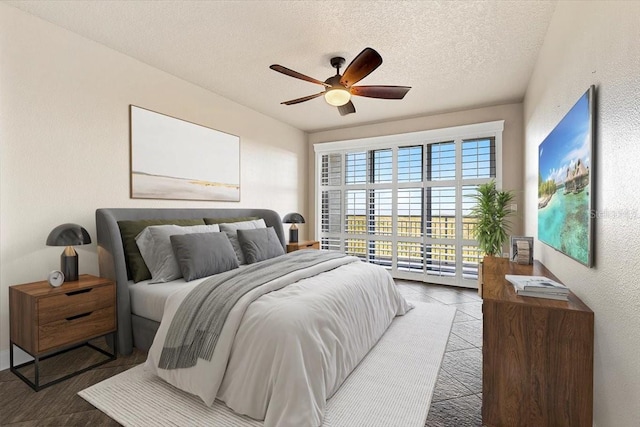 bedroom featuring ceiling fan, a textured ceiling, and access to outside