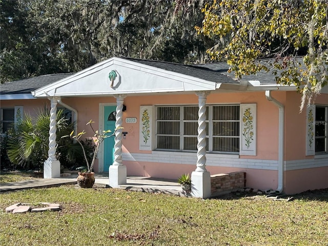 6035 Grand Blvd, New Port Richey, FL 34652 - view of front facade featuring a front yard and stucco siding