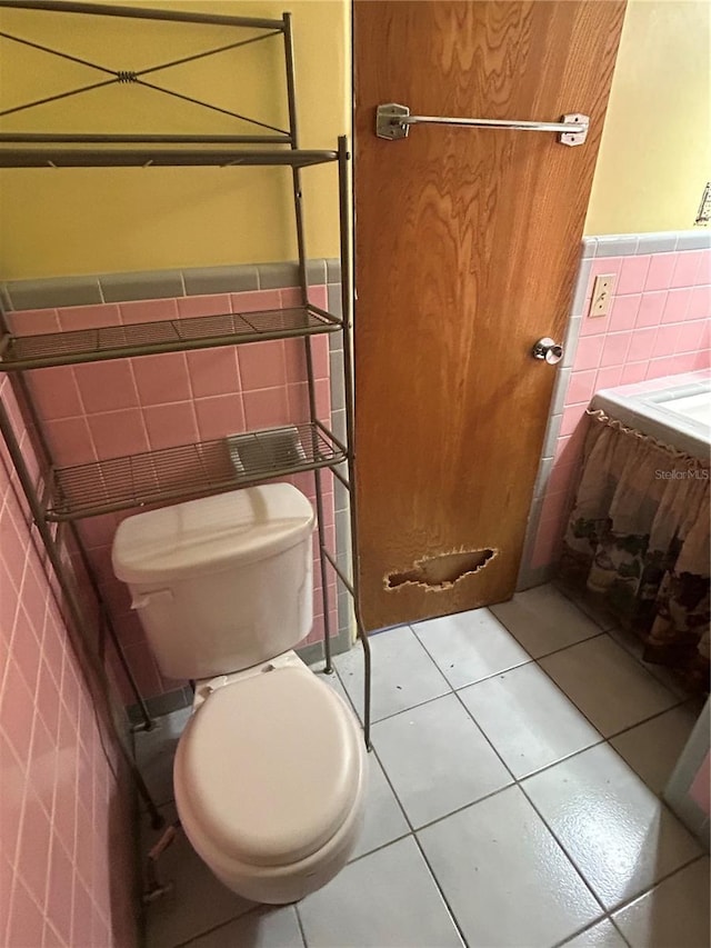 6035 Grand Blvd, New Port Richey, FL 34652 - bathroom featuring tile walls, toilet, tile patterned floors, and wainscoting