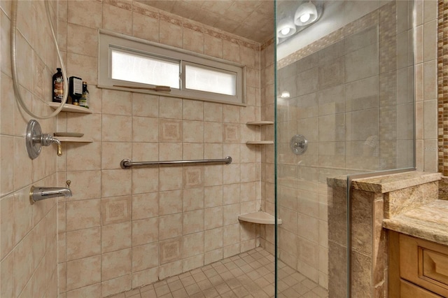 full bathroom with a tile shower and vanity