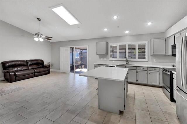 kitchen with a sink, a kitchen island, open floor plan, light countertops, and electric range oven