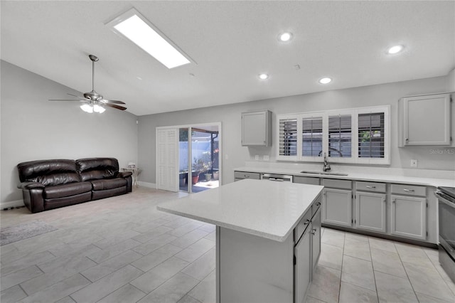 kitchen with a center island, open floor plan, light countertops, and a sink