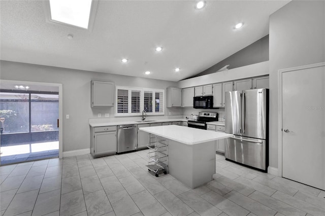 kitchen with a center island, a breakfast bar, stainless steel appliances, light countertops, and a sink