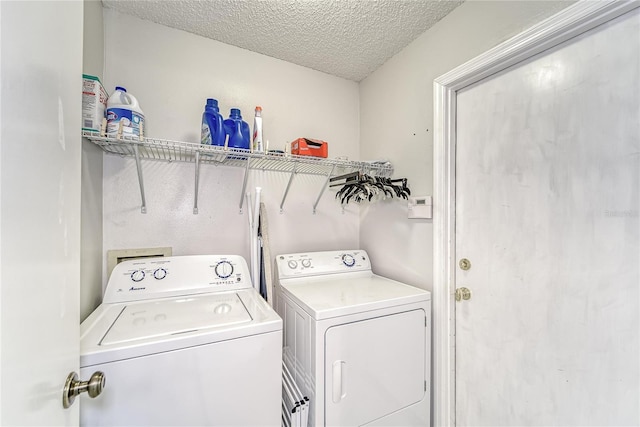 laundry area featuring laundry area, a textured ceiling, and separate washer and dryer