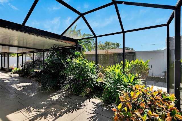 view of patio / terrace featuring glass enclosure and fence