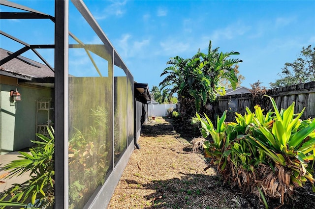 view of yard featuring glass enclosure and a fenced backyard