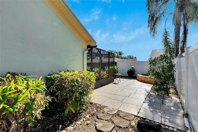 view of patio featuring glass enclosure and a fenced backyard