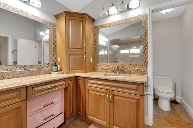 full bathroom with a stall shower, decorative backsplash, toilet, vaulted ceiling, and vanity