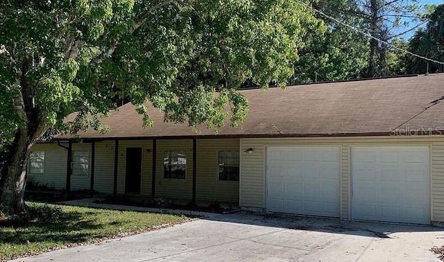 3384 Fremont Ln, Spring Hill, FL 34607 - view of front facade with an attached garage, concrete driveway, and roof with shingles