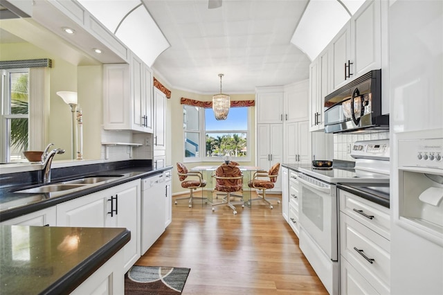 kitchen with white cabinets, white appliances, plenty of natural light, and sink